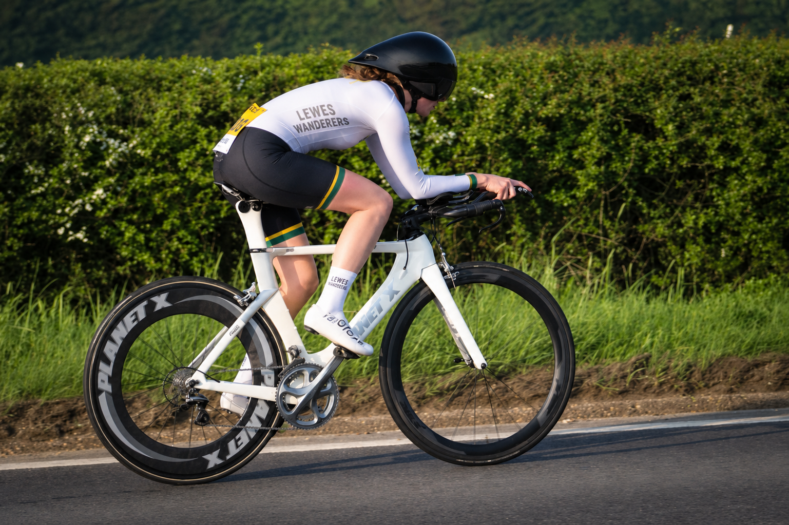 Female cycling TT rider in a white kit and in an aero position.